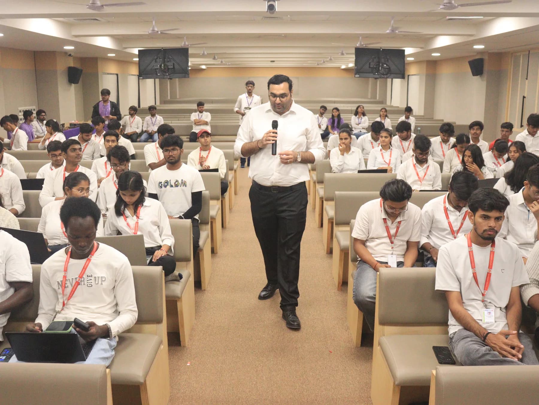 A participant with a microphone speaking among students in a PPSU auditorium